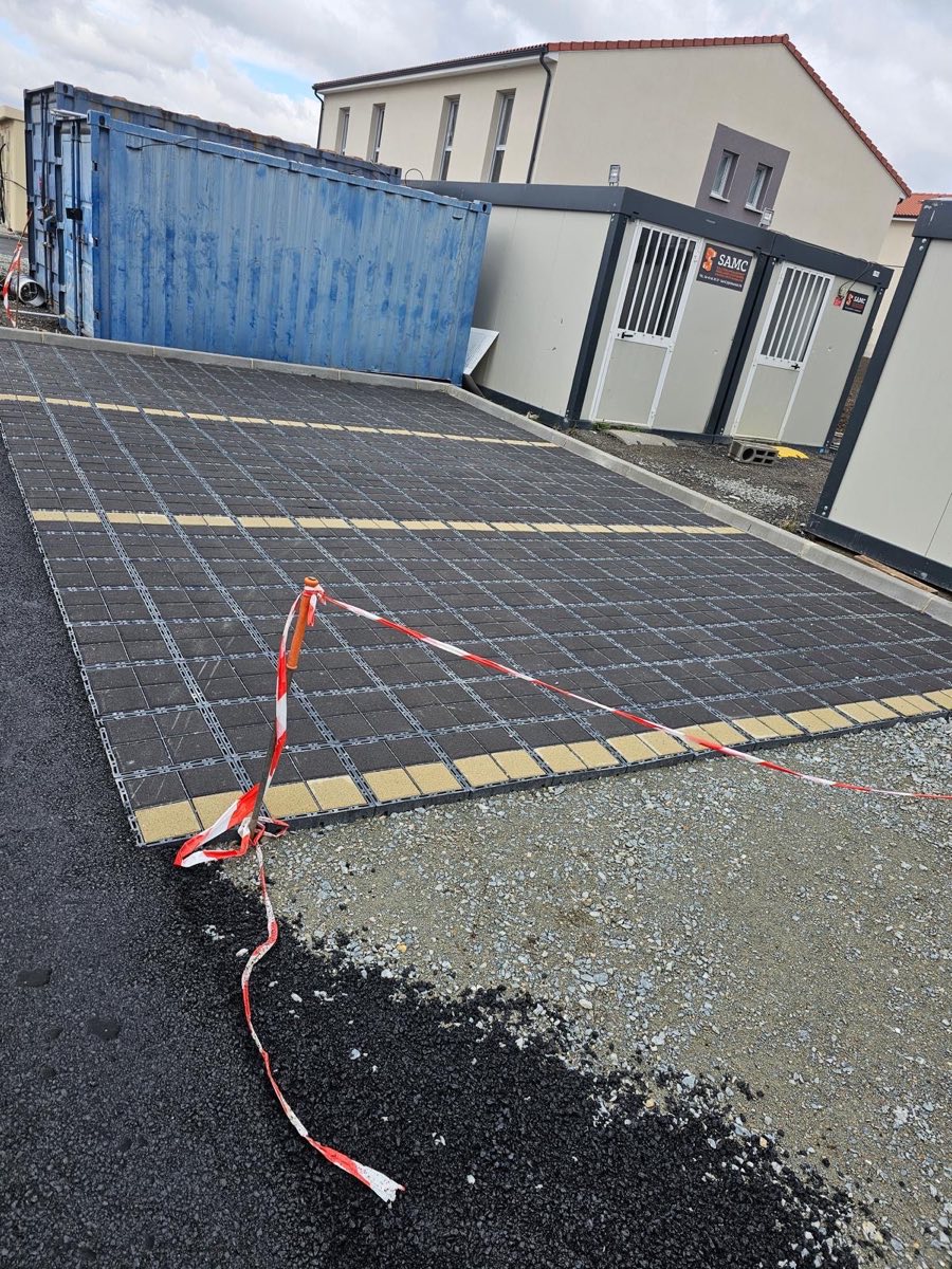 Parking en pavés alvéolés près de containers de chantier