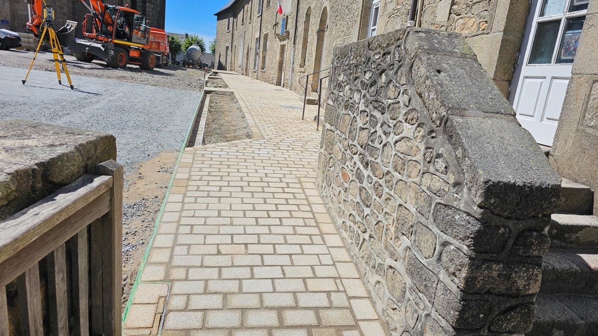 Cheminement en pavés devant un bâtiment en pierre
