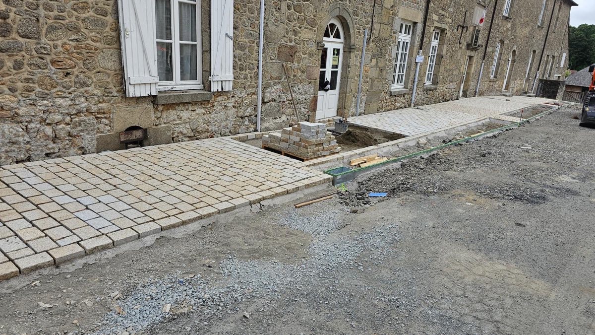 Rue de village en pavés devant des façades en pierre